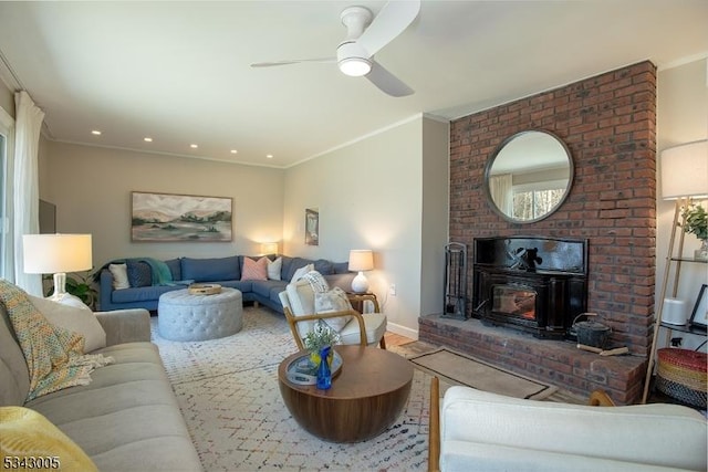 living room with a ceiling fan, baseboards, and ornamental molding