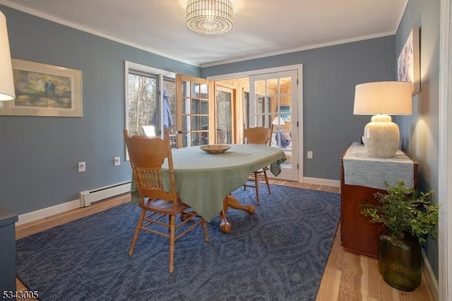 dining area featuring wood finished floors, baseboards, baseboard heating, and ornamental molding