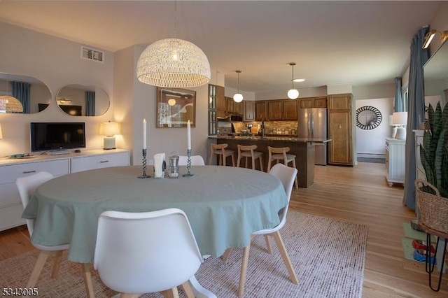 dining room featuring visible vents and light wood-type flooring