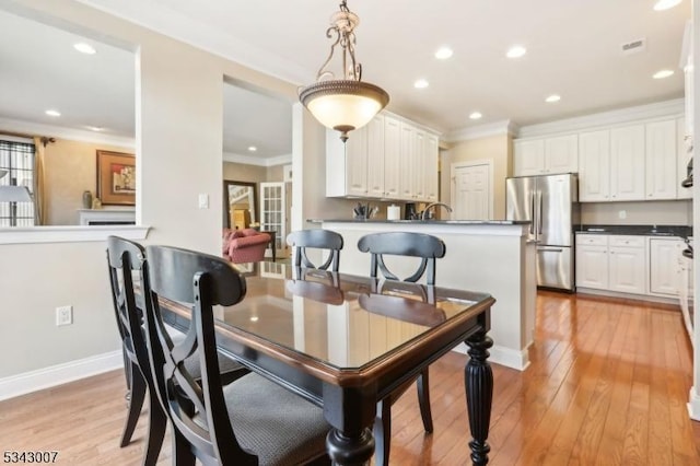 dining space featuring visible vents, ornamental molding, recessed lighting, light wood-style floors, and baseboards