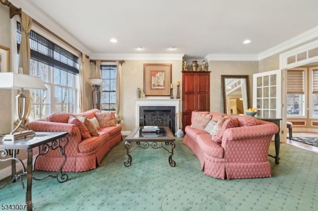 living area with a wealth of natural light, carpet flooring, a fireplace, and crown molding