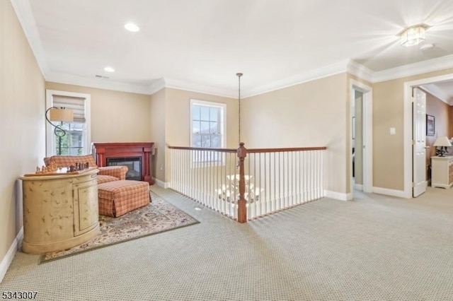 sitting room with a glass covered fireplace, recessed lighting, carpet flooring, crown molding, and baseboards