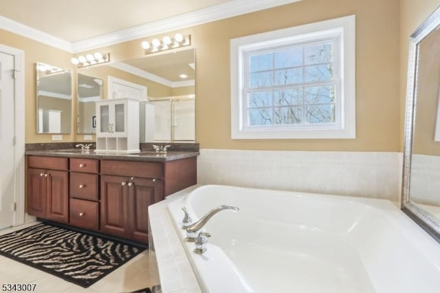 full bathroom featuring double vanity, a stall shower, a sink, ornamental molding, and a bath