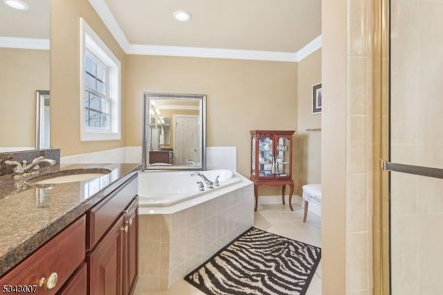 bathroom featuring tile patterned floors, crown molding, baseboards, a bath, and vanity