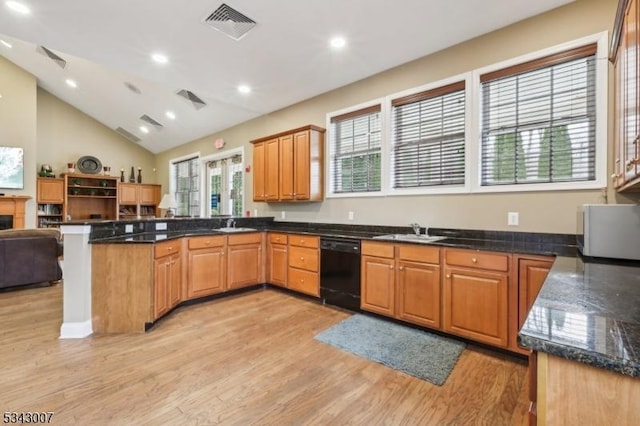 kitchen with visible vents, a peninsula, light wood-style flooring, a sink, and black dishwasher