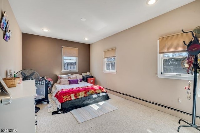 carpeted bedroom with multiple windows, recessed lighting, and a baseboard radiator