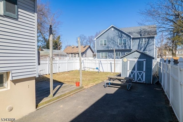 view of yard with an outbuilding, a shed, a patio, and a fenced backyard