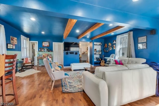 living area with beam ceiling, recessed lighting, and wood finished floors