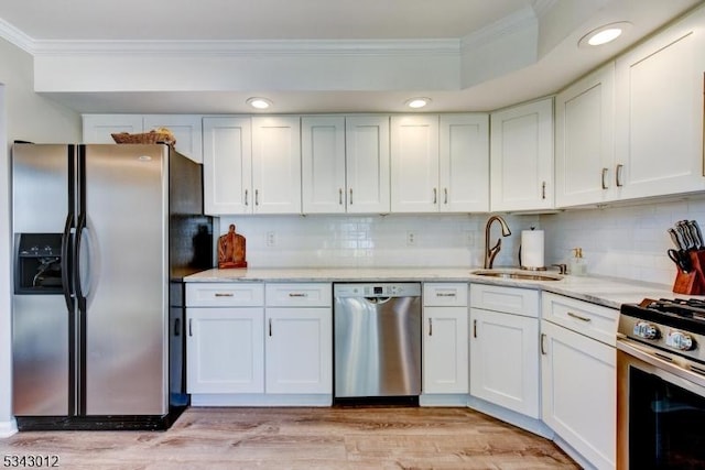 kitchen with white cabinetry, appliances with stainless steel finishes, and ornamental molding