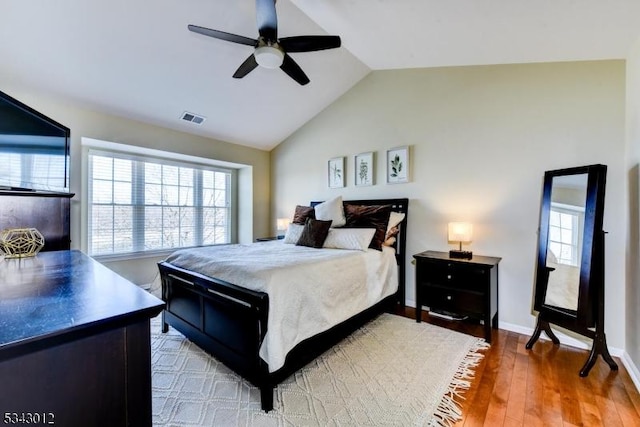 bedroom with visible vents, multiple windows, wood finished floors, and vaulted ceiling