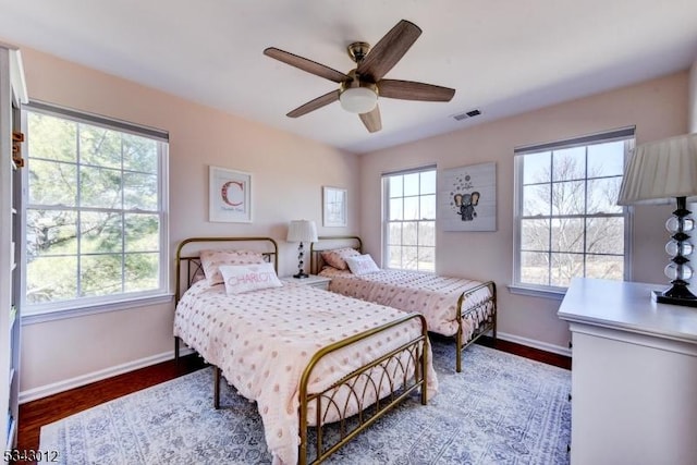 bedroom featuring visible vents, multiple windows, and baseboards