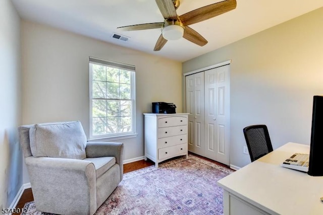 office space featuring visible vents, ceiling fan, baseboards, and wood finished floors