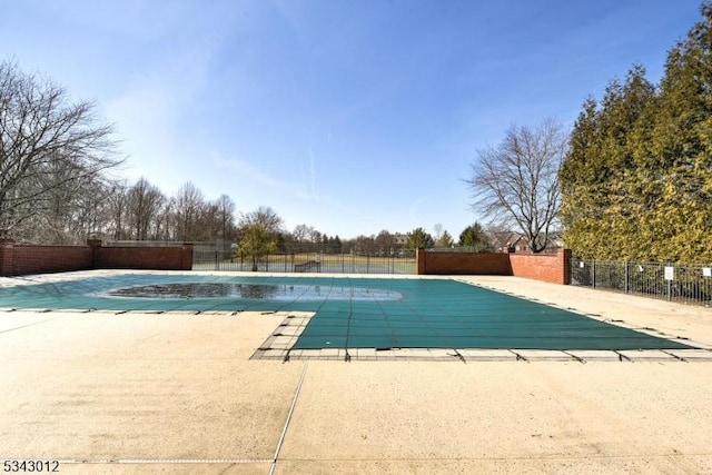 community pool with a patio and fence