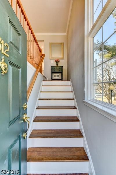 staircase with baseboards and crown molding