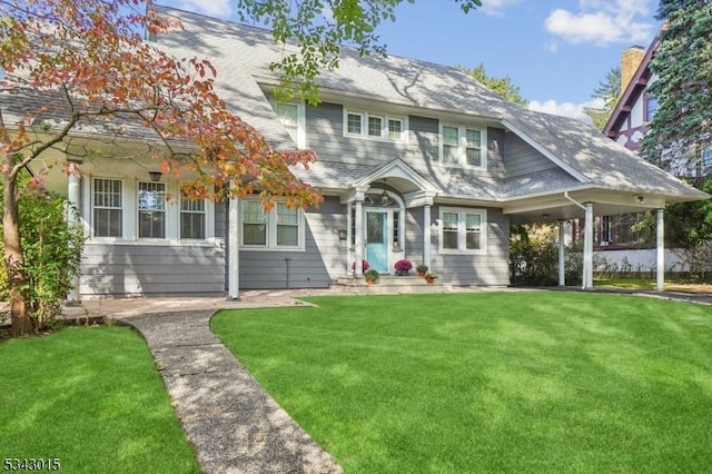 view of front of home featuring a front yard and a shingled roof