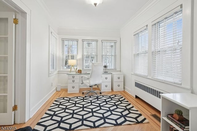 office featuring light wood-style flooring, baseboards, ornamental molding, and radiator heating unit