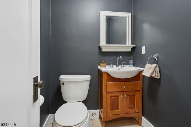 bathroom featuring tile patterned floors, baseboards, toilet, and vanity