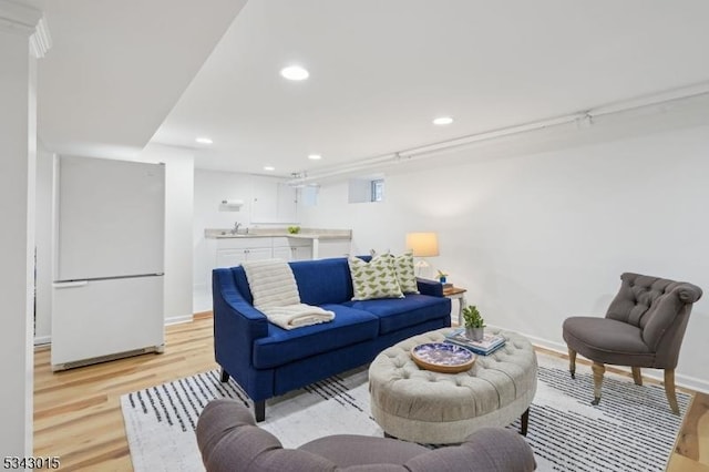 living area featuring recessed lighting, light wood-style floors, and baseboards