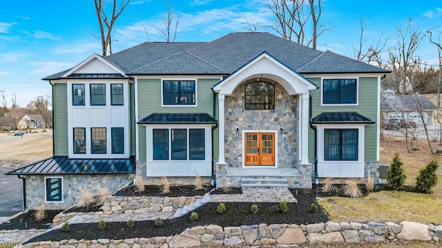 view of front of property with metal roof, stone siding, and a standing seam roof