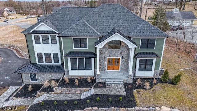 view of front of home with a standing seam roof, stone siding, and metal roof