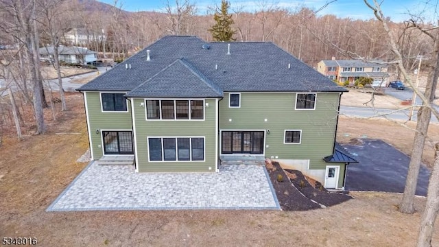 rear view of property with a shingled roof