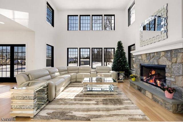 living room featuring a fireplace, a high ceiling, and wood finished floors