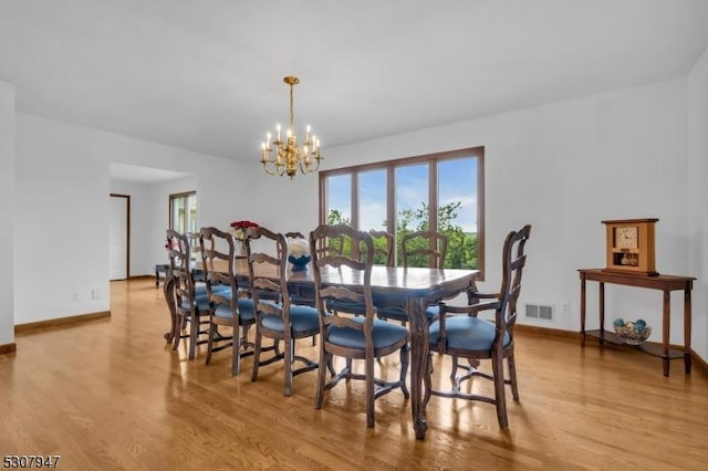 dining room with visible vents, an inviting chandelier, baseboards, and light wood-style floors