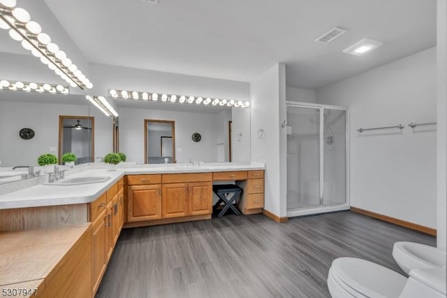 bathroom featuring visible vents, a shower stall, toilet, double vanity, and a sink