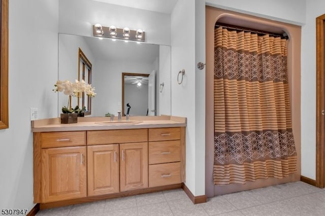 full bathroom with vanity, a shower with shower curtain, baseboards, and tile patterned floors