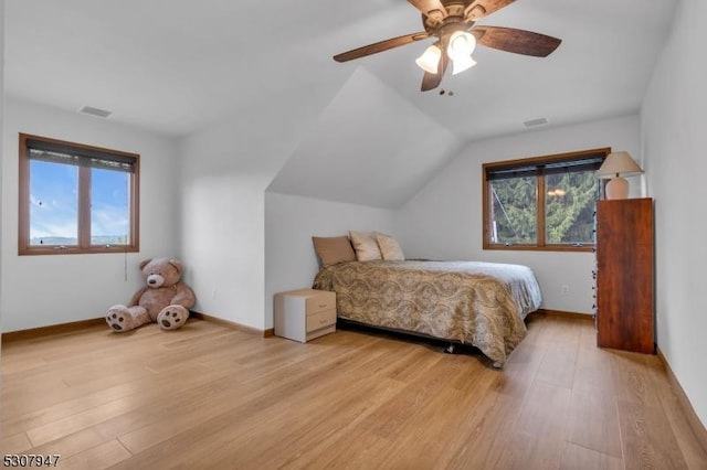 bedroom featuring light wood-style flooring, a ceiling fan, and multiple windows