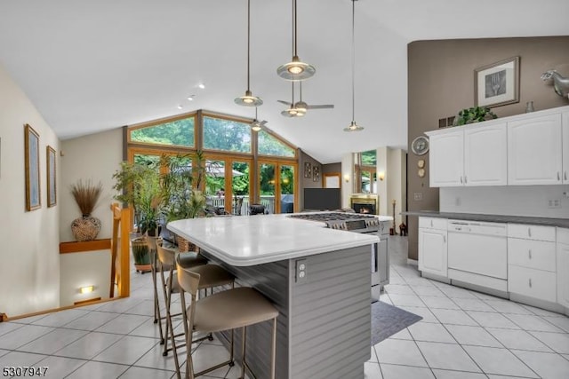 kitchen featuring light tile patterned flooring, high end stainless steel range, white dishwasher, and white cabinets