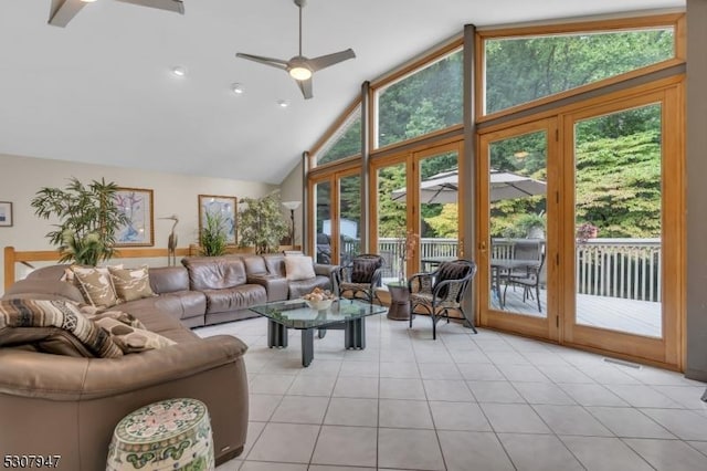 living area with light tile patterned floors, plenty of natural light, high vaulted ceiling, and ceiling fan