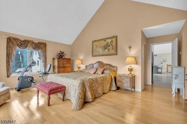 bedroom featuring light wood-style flooring and high vaulted ceiling