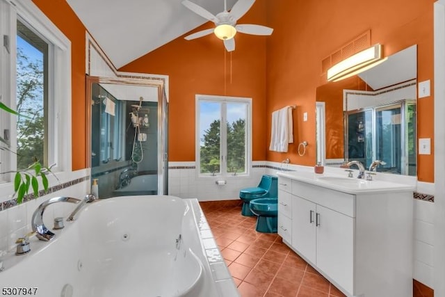 bathroom featuring tile patterned flooring, a bidet, vaulted ceiling, a whirlpool tub, and vanity