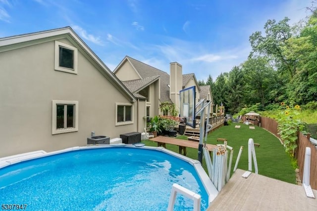 view of swimming pool with a fenced in pool, fence, cooling unit, a yard, and a deck