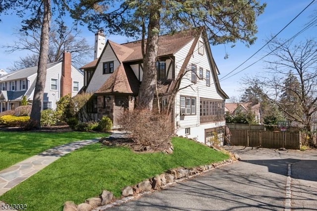 view of front of home featuring a chimney, a front yard, and fence