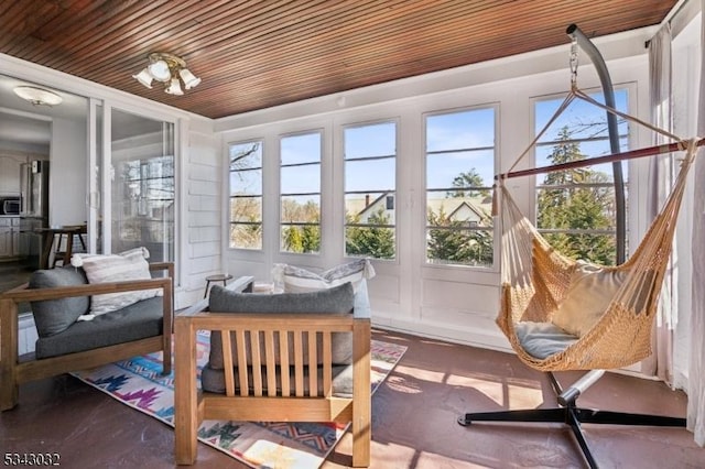 sunroom / solarium featuring a notable chandelier