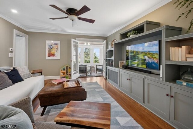 living area featuring ceiling fan, baseboards, light wood-type flooring, and ornamental molding