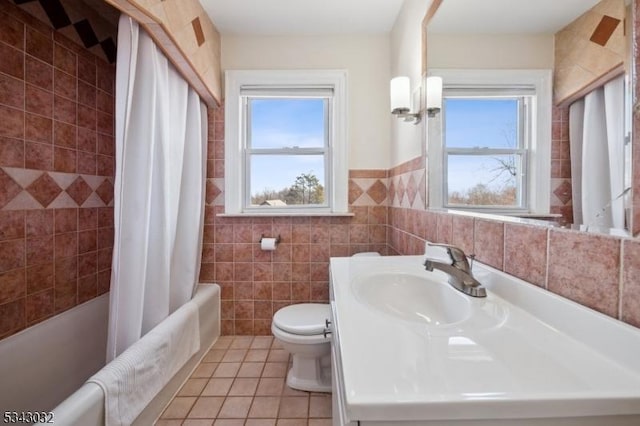 full bathroom featuring toilet, shower / bath combo, tile walls, tile patterned flooring, and vanity