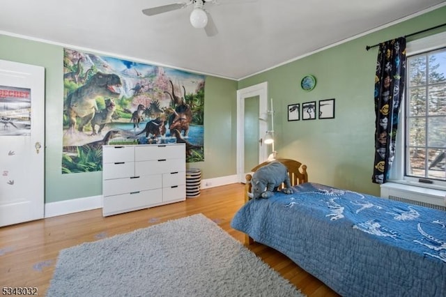 bedroom featuring baseboards, a ceiling fan, wood finished floors, and crown molding