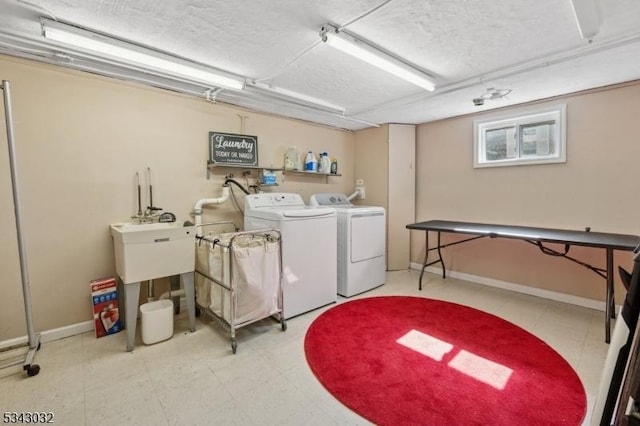 clothes washing area featuring tile patterned floors, laundry area, baseboards, and washer and clothes dryer