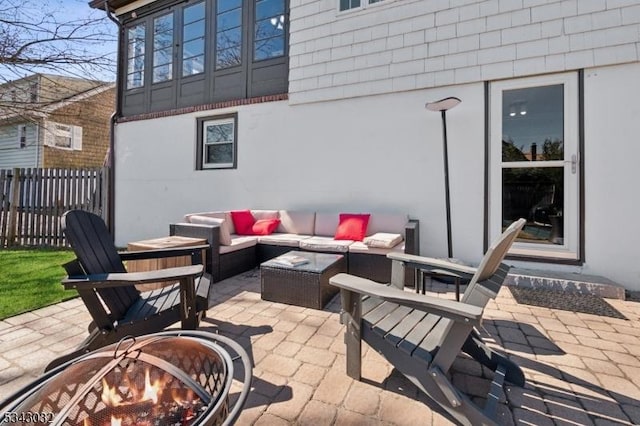 view of patio featuring an outdoor living space with a fire pit and fence