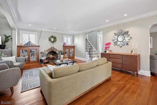 living area featuring a wealth of natural light, arched walkways, and wood finished floors