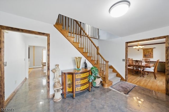 stairway featuring an inviting chandelier and baseboards