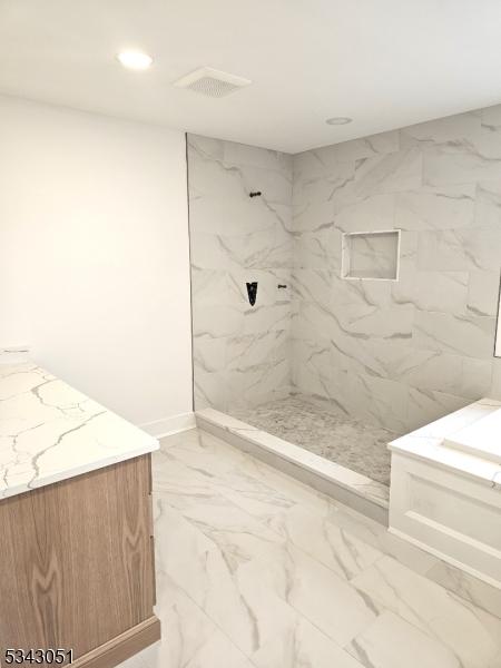 full bath with a marble finish shower, recessed lighting, marble finish floor, and vanity