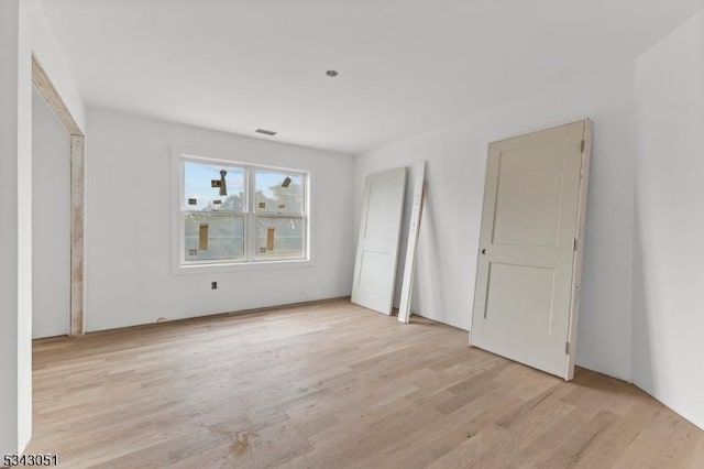 unfurnished bedroom featuring visible vents and light wood-type flooring