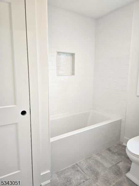 bathroom featuring toilet and shower / bath combination