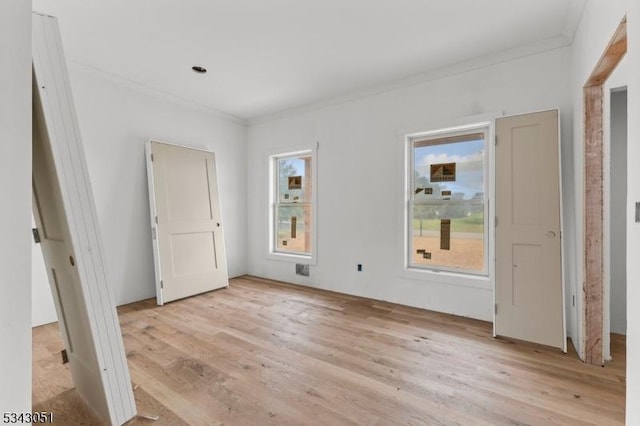 unfurnished bedroom with crown molding and light wood-style flooring