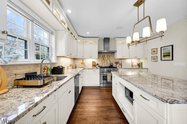 kitchen featuring stainless steel appliances, dark wood finished floors, decorative backsplash, and wall chimney range hood