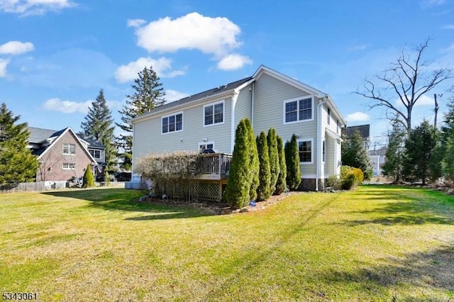 back of property with a wooden deck and a yard